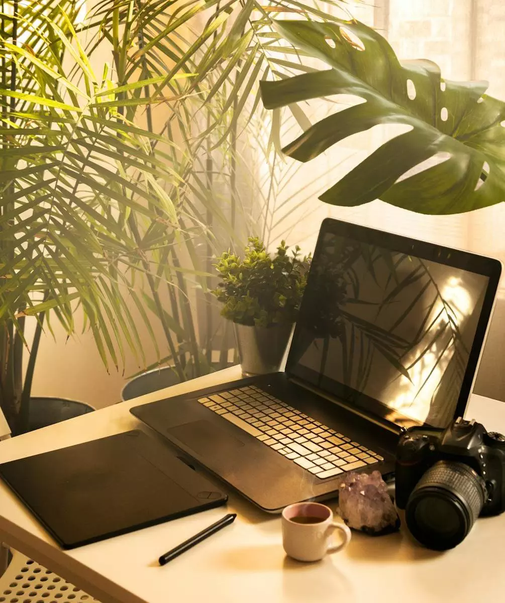 black and silver laptop beside a camera on wooden table